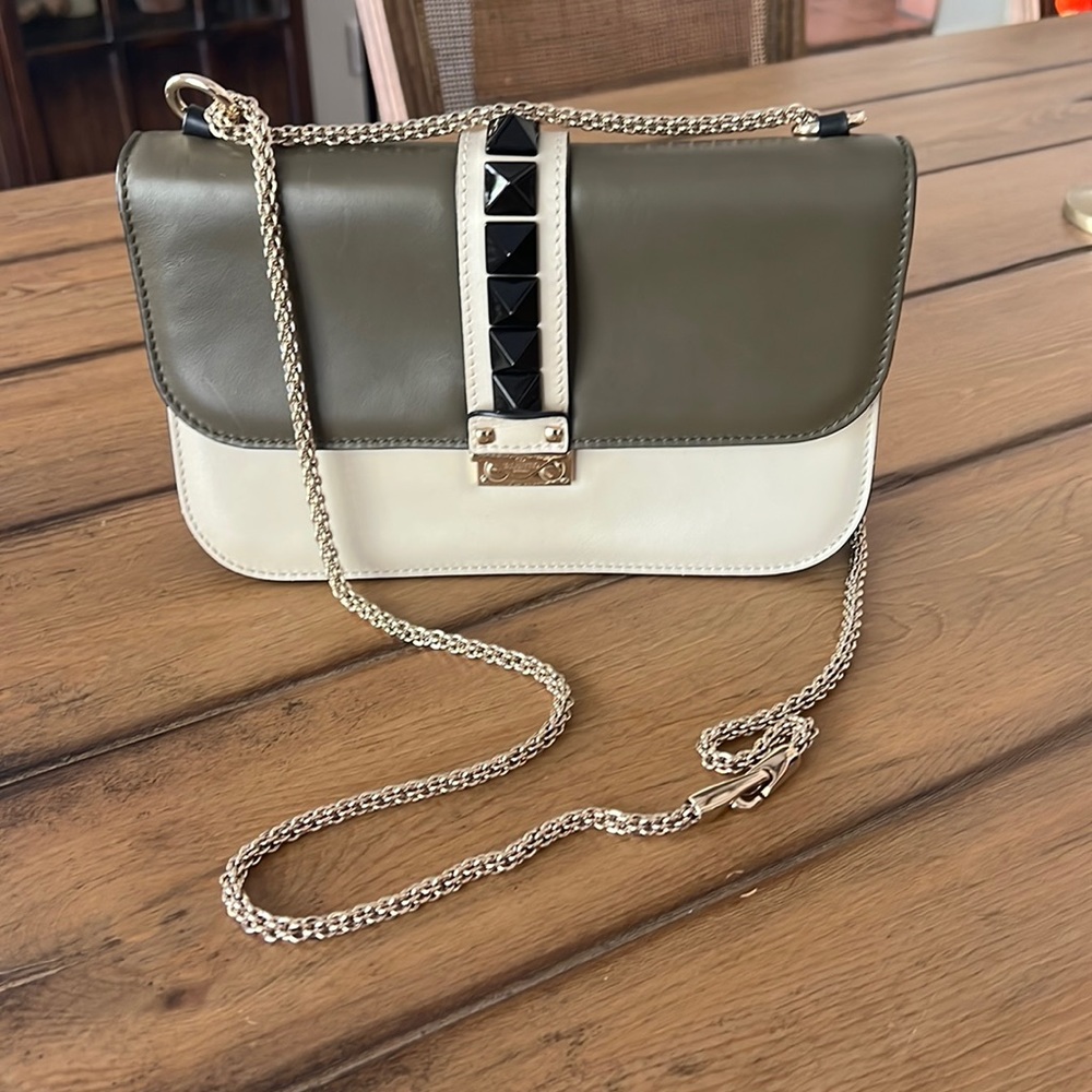 Valentino Garavani glam lock rockstud flap bag in green and cream.